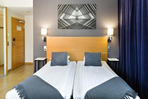 哥德堡Hotel Allén - Sure Hotel by Best Western Allen的一间卧室配有一张带两个蓝色枕头的床