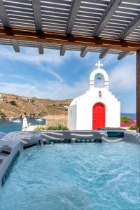 超级天堂海滩Etesians Suites & Villas的教堂和红色门的游泳池