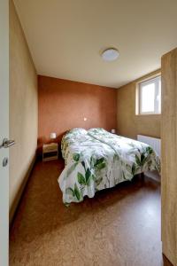 德哈恩Aan de duinbossen的一间卧室配有一张带绿色棉被的床