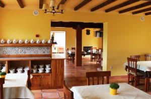 卡巴塞诺Posada Cabárceno的餐厅拥有黄色的墙壁和桌椅
