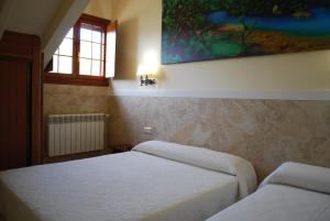 卡巴塞诺Posada Cabárceno的一间卧室设有两张床,墙上挂着一幅画