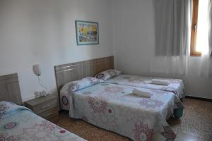 莫甘海滩伊娃旅馆的一间卧室设有两张床和窗户。