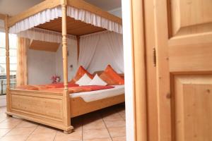 特赖斯-卡尔登科奈普旅馆的卧室配有带枕头的木制天蓬床