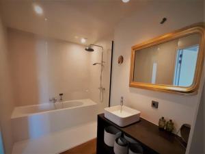 科特赖克Broel4的一间带水槽、浴缸和镜子的浴室