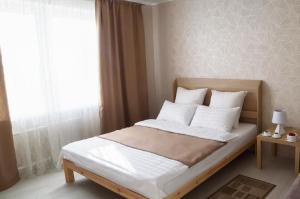 索利戈尔斯克PaulMarie Apartments on Kozlova的卧室配有带白色枕头的床和窗户。