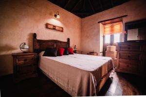 蒂哈拉费Casa Elena的一间卧室配有一张带红色枕头的床和一扇窗户