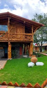 Puembo赞桑特山林小屋的草上带屋顶的木结构建筑