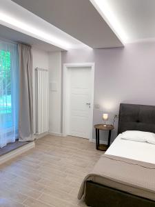 乌尔比诺天堂住宿加早餐旅馆的白色的卧室设有床和窗户