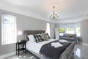 贝尔法斯特Chestnut House, Sleeps 11, Beautiful, spacious & comfortable的白色卧室设有一张大床和一张沙发