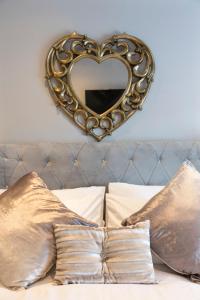 贝尔法斯特Chestnut House, Sleeps 11, Beautiful, spacious & comfortable的床上方墙上的心形镜子