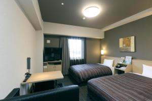 静冈Hotel Route-Inn Shimizu Inter的酒店客房配有两张床和一张书桌