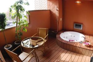 川口市HOTEL IKOI (Adult Only)的甲板上的热水浴池配有桌椅