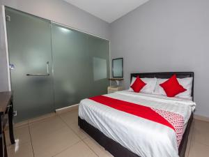 马六甲OYO 1185 Ho Hotel的一间卧室配有一张带红色枕头的大床