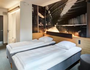 奥尔堡Zleep Hotel Aalborg的墙上画画的房间里设有两张床