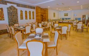 曼德勒Mandalay Lodge Hotel的一间在房间内配有桌椅的餐厅