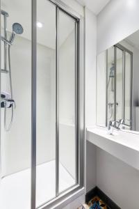 阿尔戈奈hotelF1 Annecy Argonay的带淋浴、盥洗盆和镜子的浴室