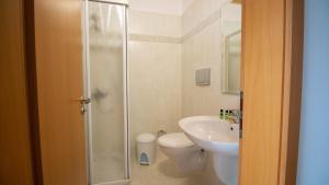 萨兰达Sun N Blue Hotel的带淋浴、卫生间和盥洗盆的浴室