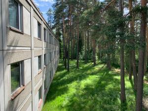 福尔萨Hotelli Mesku Forssa的公寓大楼设有绿地庭院,毗邻树木