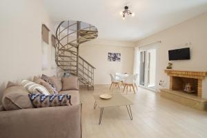 凯法利尼亚岛Rose Maisonette的带沙发和螺旋楼梯的客厅