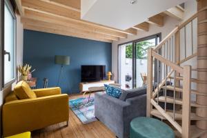 雷恩Ernestine by Cocoonr的客厅设有蓝色的墙壁和楼梯。