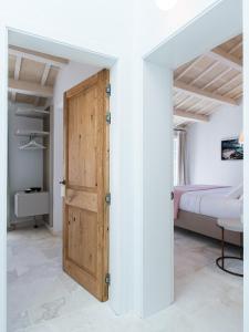 休达德亚Samarés的一间卧室设有木门和一张床