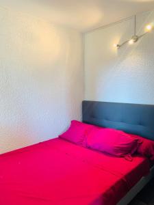 格吕桑La Pinède的一间卧室配有一张红色的床和蓝色床头板
