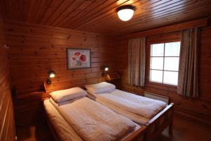 蓬卡哈尤Hapimag Ferienwohnungen Punkaharju的木制客房内的一间卧室配有两张床