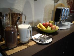 亨施泰特-乌尔茨堡阿瑞娜酒店的装有一碗水果和一杯牛奶的柜台