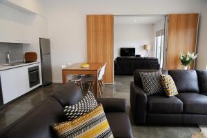 Relbia雷尔比亚酒店的一间带两张沙发的客厅和一间厨房