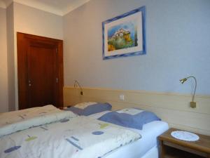 Heffingen山谷旅馆的卧室配有两张床,墙上挂着一幅画