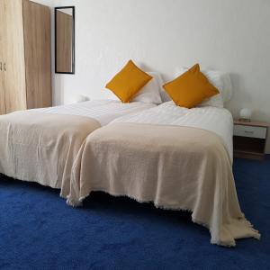 凯尔克拉B&b Broodhuis Kerkrade的一间卧室配有两张带白色和黄色枕头的床