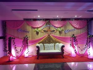 NavsāriHotel Shahi Darbar的粉红色窗帘前的带床的舞台