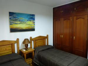 卡索拉Casa La Antigua Almazara的一间卧室设有两张床,墙上挂着一幅画