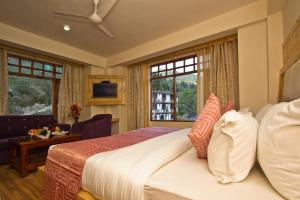 马拉里Hotel Hayer Regency的酒店客房带床、沙发和窗户