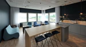 恩舍尔兹维克恩舍尔兹维克瑞典精英酒店的厨房配有大型木桌和蓝色椅子