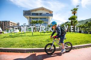 加尔达湖滨航海中心公寓酒店的骑着自行车沿着街道走的男孩