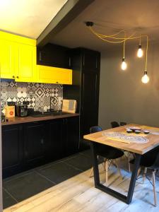 布加勒斯特Lascăr Catargiu Vila的厨房配有木桌和黄色橱柜。