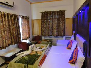 阿格拉Hotel Taj Plaza, VIP Road, Agra的一间设有两张床、椅子和窗帘的房间