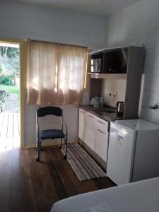 格拉玛多Chalé da Tranquilidade的一间带椅子和冰箱的小厨房