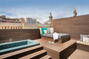 巴塞罗那Praktik Èssens的一个带热水浴缸和长凳的屋顶露台