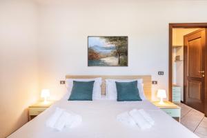 西尔米奥奈新期酒店的卧室配有带蓝色枕头的大型白色床