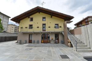 奥斯塔Vecchio Mulino Guest House的黄色房子的顶部设有阳台
