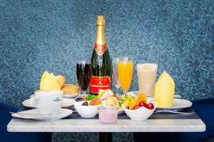 不莱梅Monopol Boutique Hotel的一张桌子,上面放着一瓶香槟、食物和饮料