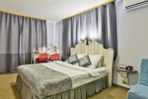 鄂木斯克朱可夫宾馆的一间卧室配有一张大床和一张蓝色椅子
