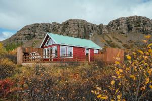 博尔加内斯Mulakot Cosy Cabins的一座红色的房子,后面有山