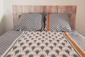 Penne-dʼAgenaisLa Cabane的一张带木制床头板的床和床罩