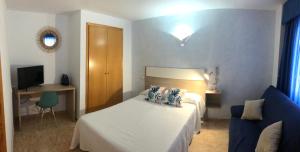 塔韦尔内斯德拉瓦利迪格纳Hotel Valldigna的卧室配有白色的床和蓝色的沙发