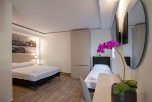 布德瓦Casa Mia的一间卧室设有两张床和一张带花卉的桌子