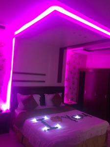 海米斯穆谢特Lamset Aseer Chalets的卧室配有紫色灯光,位于床上