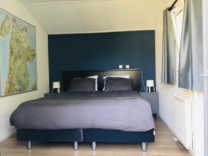 Hensbroekchalet hensbroek的一间卧室设有一张蓝色墙壁的大床